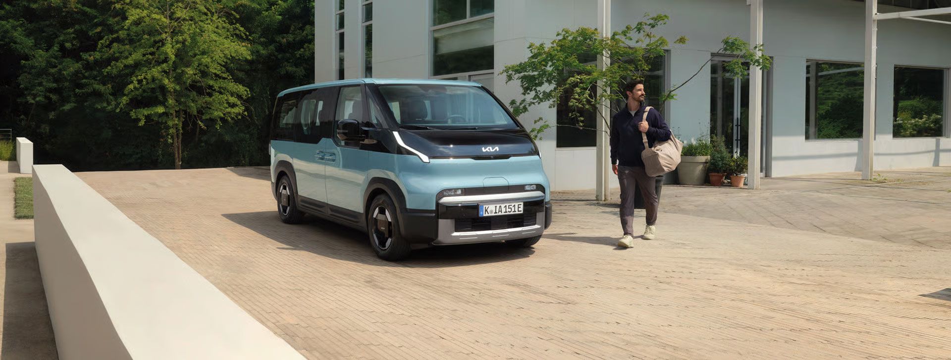 Kia PV5 Passenger vor einem  Gebäude in Vorderansicht mit Talent
